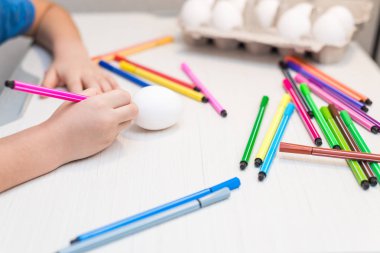 Bir çocuk Keçeli Kalemler ile Paskalya yumurtaları boya. Paskalya fikirler. Metin için yer. Yumurta tepsi. Mutlu Paskalya.