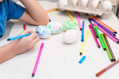 Bir çocuk Keçeli Kalemler ile Paskalya yumurtaları boya. Paskalya fikirler. Metin için yer. Yumurta tepsi. Mutlu Paskalya.