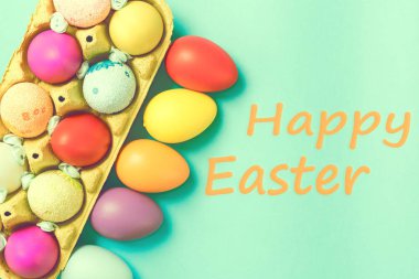 Bir kutu mavi bir arka plan üzerinde yalanımı parlak Paskalya yortusu yumurta