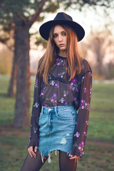 Mooi meisje in een denim rok en een transparante blouse. — Stockfoto