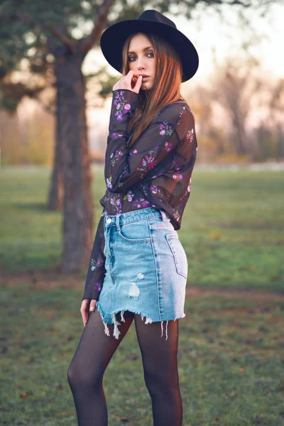 Красивая девушка в джинсовой юбке и прозрачной блузке . — стоковое фото