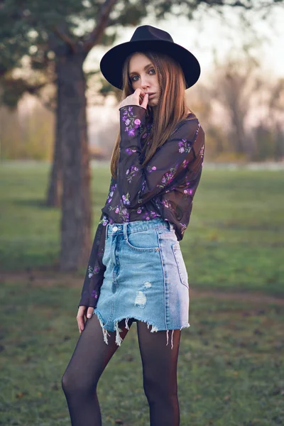 Schöne Mädchen in einem Jeansrock und einer transparenten Bluse. — Stockfoto