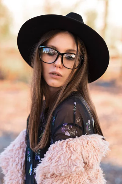 Hermosa morena en gafas de moda y un abrigo peludo . —  Fotos de Stock