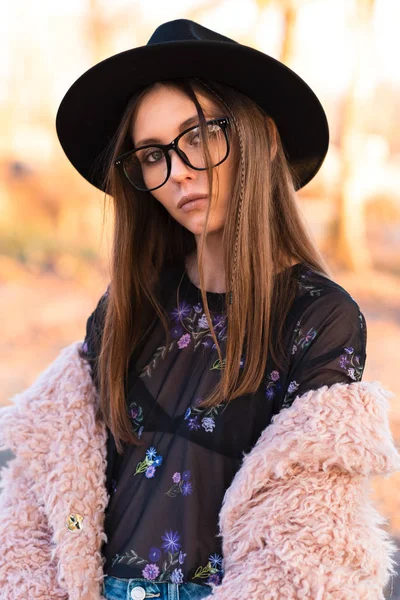 Schöne Brünette mit modischer Brille und struppigem Mantel. — Stockfoto