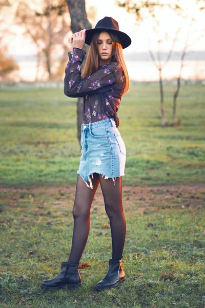 Красивая девушка в джинсовой юбке и прозрачной блузке . — стоковое фото