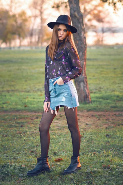 Menina bonita em uma saia de ganga e uma blusa transparente . — Fotografia de Stock