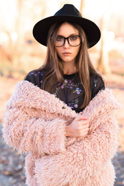 Schöne Brünette mit modischer Brille und struppigem Mantel. — Stockfoto