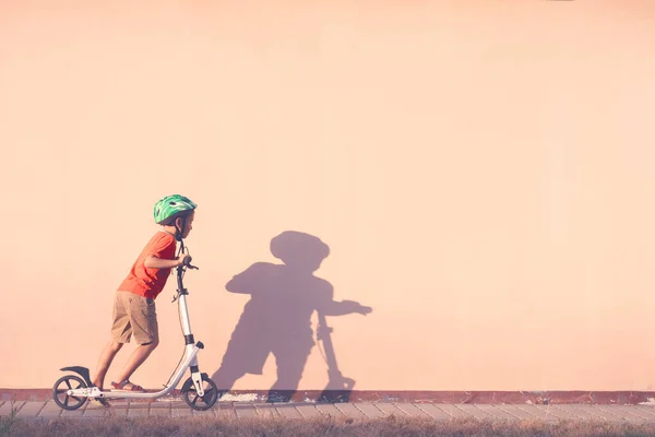 The child is engaged in riding a white scooter. — Stock Photo, Image