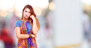 Genç güzel kız açık ve alnına işaret parmağı kolu ile düşünme Concentrating uzak de ciddi bir göz, bir fikirle sert geçti.