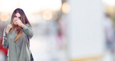 öfkeyle ve kati yumruk gösteren genç güzel kızla bir öfkeli, agresif ve tehditkar poz, dövüş için hazır.