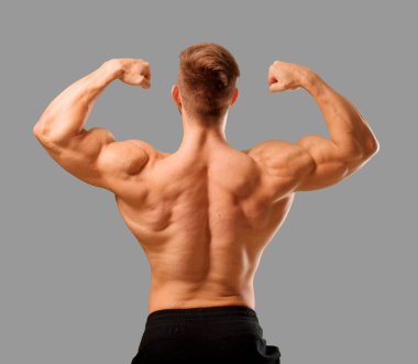 Genç yakışıklı vücut geliştirmeci adam kas görünümü ile poz