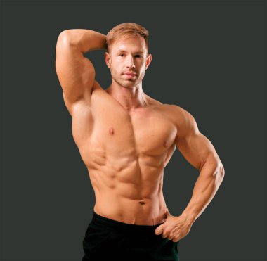 young handsome bodybuilder man posing with muscular appearance clipart