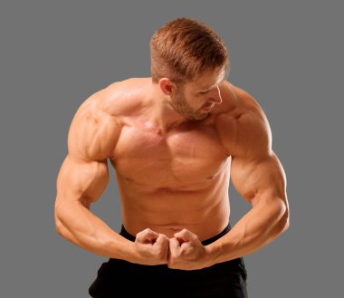 Genç yakışıklı vücut geliştirmeci adam kas görünümü ile poz