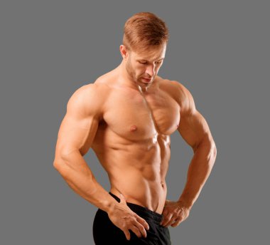 Genç yakışıklı vücut geliştirmeci adam kas görünümü ile poz
