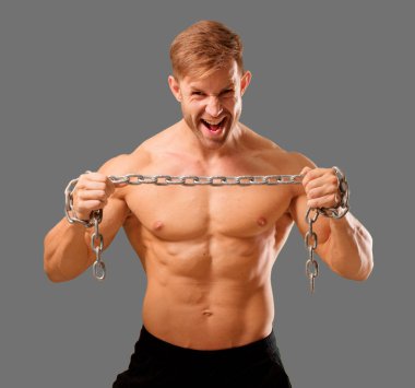 Genç yakışıklı vücut geliştirmeci adam kas görünümü ile poz