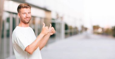 Tamam iki elle sinyal, bir pozitif, gönderme genç sarışın adam, yaşasın ile memnun, gururlu ve mutlu bir bakışla 