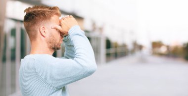 şaşkın bir bakışla uzak bir nesne için arama mesafe içine uzakta arıyorum Genç sarışın adam. Yanal veya yan görünüm.