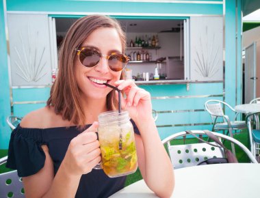 bir restoranda taze mojito kokteyl sahip genç güzel kadın