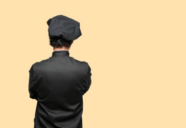 Kameranın önünde bir nesne doğru seyir çarpı işareti, silah ile ayakta, geri vererek bir şef olarak genç deli adam. Kızgın, memnun, gurur, düşünceli küstah ifade olabilir.