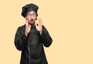 öne eğilerek ve bir sır ile ciddi bir ve sürpriz fısıldayan bir şef olarak genç deli adam yüzünde bak