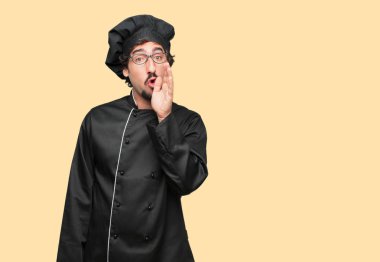 öne eğilerek ve bir sır ile ciddi bir ve sürpriz fısıldayan bir şef olarak genç deli adam yüzünde bak