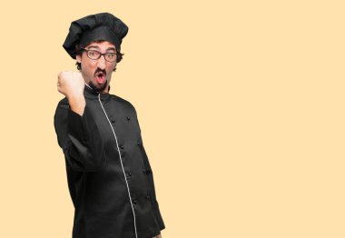 bir başarı kutluyor zafer, yüz ve holding kol gücü veya başarı, gösterilen basıldığında, yumruk ile mutlu, gururlu ve memnun bir bakışla el hareketi bir şef olarak genç deli adam.