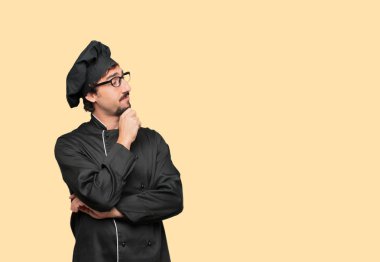 yana doğru seyir, düşünme ve farklı seçenekler arasında merak bir şef ile karışık ve düşünceli bir görünüm olarak genç deli adam.