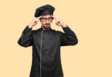 Genç deli adam alnına işaret her iki işaret parmakları ile düşünüyor Şef Concentrating ciddi bir bakışla bir fikri üzerine sabit olarak.