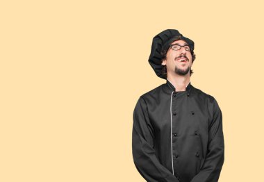 gülümseyen ve yukarı doğru gökyüzüne doğru veya nereye gazeteci bir kavram ya da mesaj yer noktaya bakarak bir şef olarak genç deli adam.