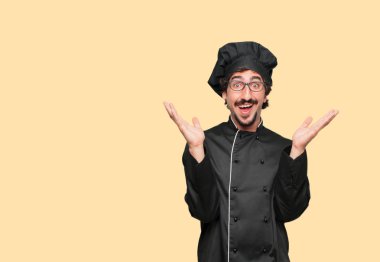 mutlu bir sürpriz ifade ile şef olarak genç deli adam, gözleri geniş açık ve geniş gülümseme, yüz şok gösterilen her iki tarafında elle.