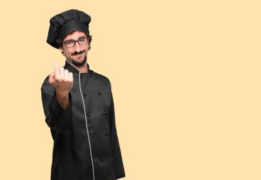 Sanki bir meydan okuma, başarısını kendine güvenen kabul bir jest yapma gurur, memnun ve mutlu bir görünüm ile gülümseyen bir şef olarak genç deli adam.