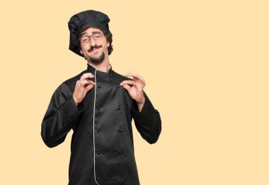 gurur, mutlu ve kendine güvenen bir ifade ile bir şef olarak genç deli adam; gülümseyen ve emin başarı, bir 