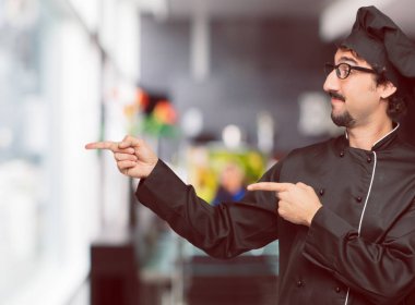 gülümseyen ve yan gazeteci bir kavram nerede gösterebilir yer doğru iki eliyle işaret eden bir şef olarak genç deli adam.