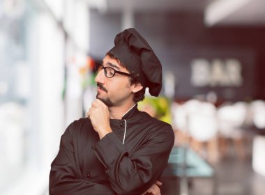 yana doğru seyir, düşünme ve farklı seçenekler arasında merak bir şef ile karışık ve düşünceli bir görünüm olarak genç deli adam.