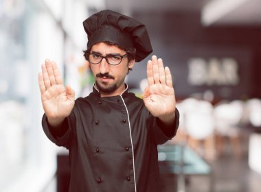 Genç deli adam bir şef sinyal son her iki avuç içi ileri, ciddi ve sert bir ifade ile karşı karşıya el ile olarak yasaklayan.