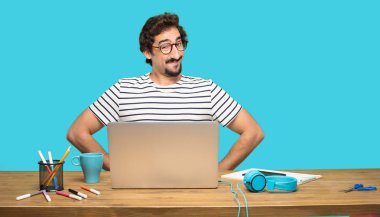 Genç tasarımcı kalça üzerinde iki eliyle gurur, memnun ve mutlu bir görünüm ile güvenle bakan bir meydan okuma sanki sakallı. Akimbo silah geniş bir gülümseme ile poz.