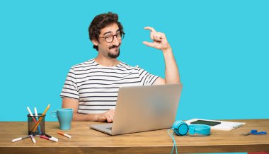 Tasarımcı bir nesne veya her iki el arasında yanal düzenlenen kavramı gösterilen memnun bir ifadeyle gülümseyen Genç sakallı.