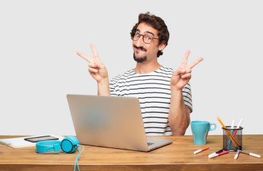 gurur, mutlu ve kendine güvenen bir ifade ile bir dizüstü bilgisayar ile Genç sakallı grafik tasarımcı; gülümseyen ve göstermek uzakta başarı ise her iki el ile el zafer zafer kutluyor bir 