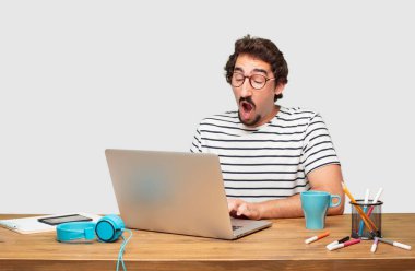 genç grafik tasarımcı ile bir dizüstü Looking isteksiz sıkılmış, bir şey sıkıcı ve sıkıcı, halis can sıkıntısı esneme için dinleme ve sakallı.