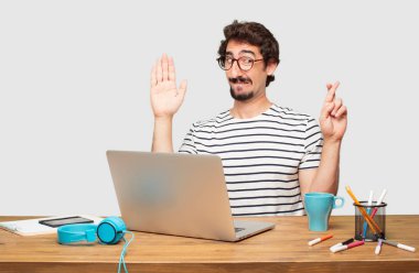 genç grafik tasarımcı bir samimi söz ver yoksa yemin, yaparken güvenle gülümseyen bir dizüstü bilgisayar ile tek eliyle kalp üzerinde ciddiyetle küfür sakallı.