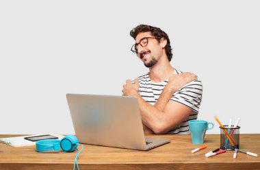 genç grafik tasarımcı bir gurur, kendinden emin ve mutlu bir görünüm, gülümseyen ve duygu memnun, yanal veya yan görünümü ile bir dizüstü bilgisayar ile sakallı.