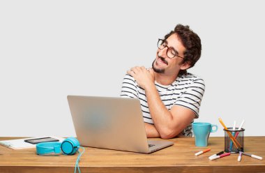 genç grafik tasarımcı bir gurur, kendinden emin ve mutlu bir görünüm, gülümseyen ve duygu memnun, yanal veya yan görünümü ile bir dizüstü bilgisayar ile sakallı.