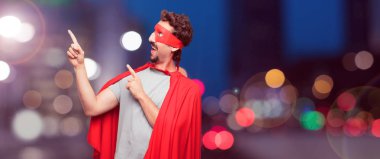 gülümseyen ve yukarı doğru nerede gazeteci bir kavram gösterebilir miyim yere doğru iki eliyle işaret eden bir süper kahraman olarak çılgın adam.