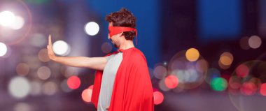 deli adam dur her iki avuç ileri, ciddi ve sert bir ifade ile karşı karşıya el sinyal bir süper kahraman olarak yasaklayan. Orta yan cepheden görünüm.