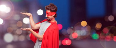 bir nesne veya her iki el arasında yanal düzenlenen kavramı gösterilen memnun bir ifadeyle gülümseyen bir süper kahraman olarak çılgın adam.