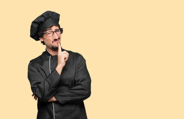 young crazy man as a chef with a confused and thoughtful look, looking sideways, thinking and wondering between different options.