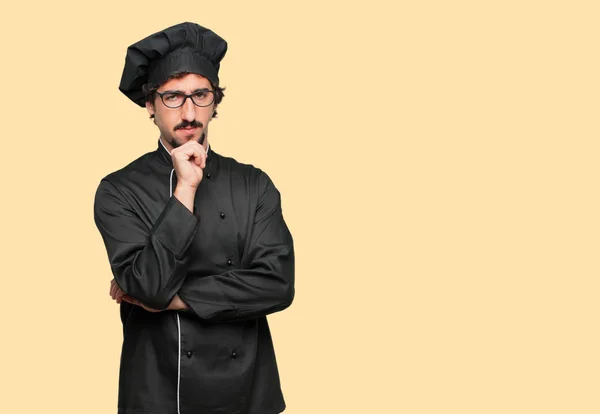 young crazy man as a chef with a confused and thoughtful look, looking sideways, thinking and wondering between different options.