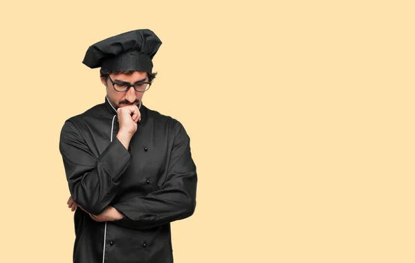young crazy man as a chef with a confused and thoughtful look, looking sideways, thinking and wondering between different options.