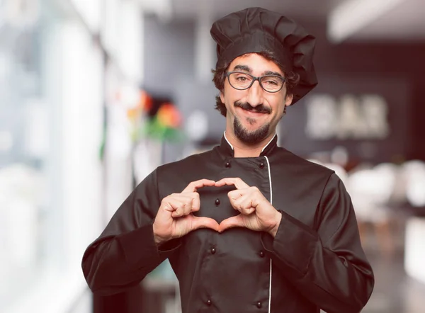 年轻的疯狂的人作为厨师微笑 看愉快和在爱 做心脏的形状用手 — 图库照片
