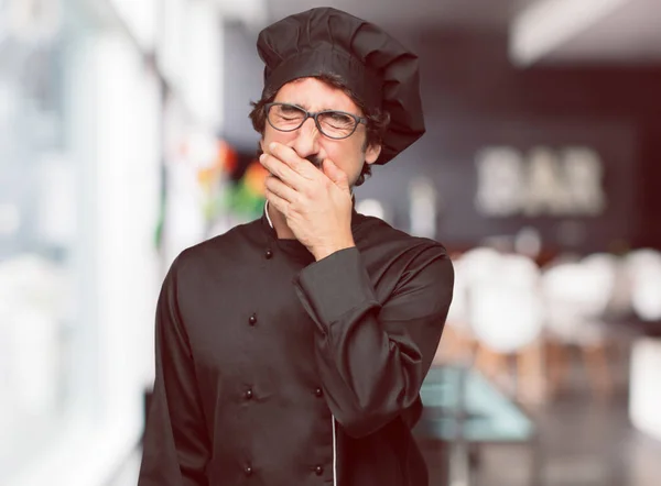 young crazy man as a chef Laughing out loud with head tilted backwards and happy, cheerful expression